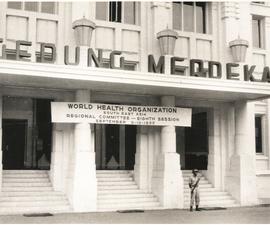 Spanduk yang menunjukan peran serta WHO dalam KAA yang diselenggarakan di Gedung Merdeka Bandung